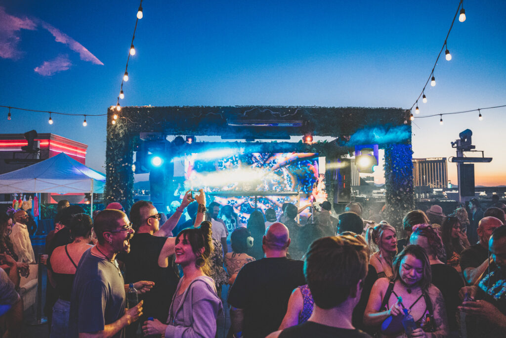 Crowd illuminated by stage lighting on rooftop club in Las Vegas