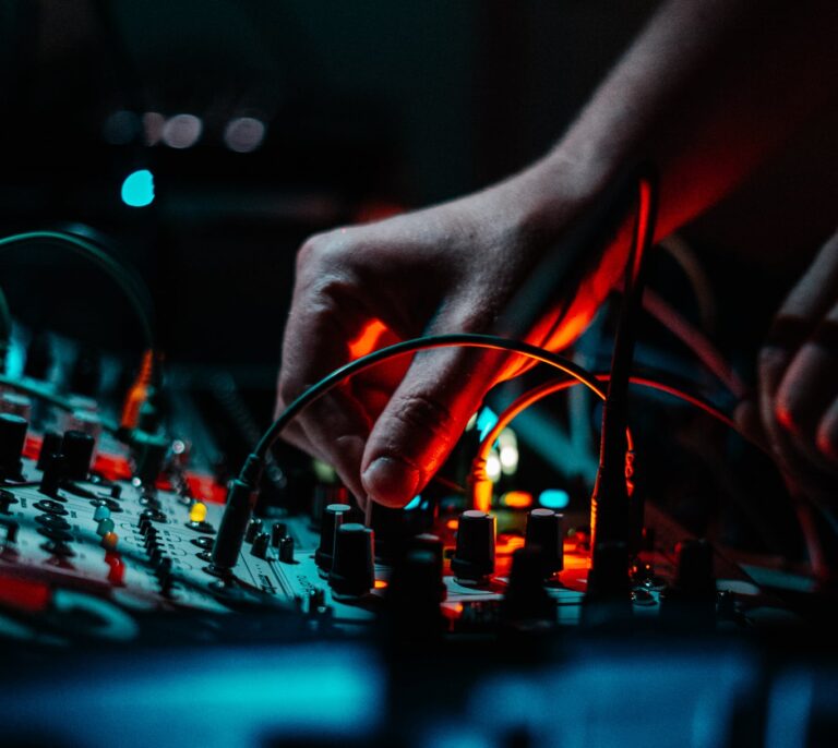 Up close image of a DJ's hand twisting knob on club mixer