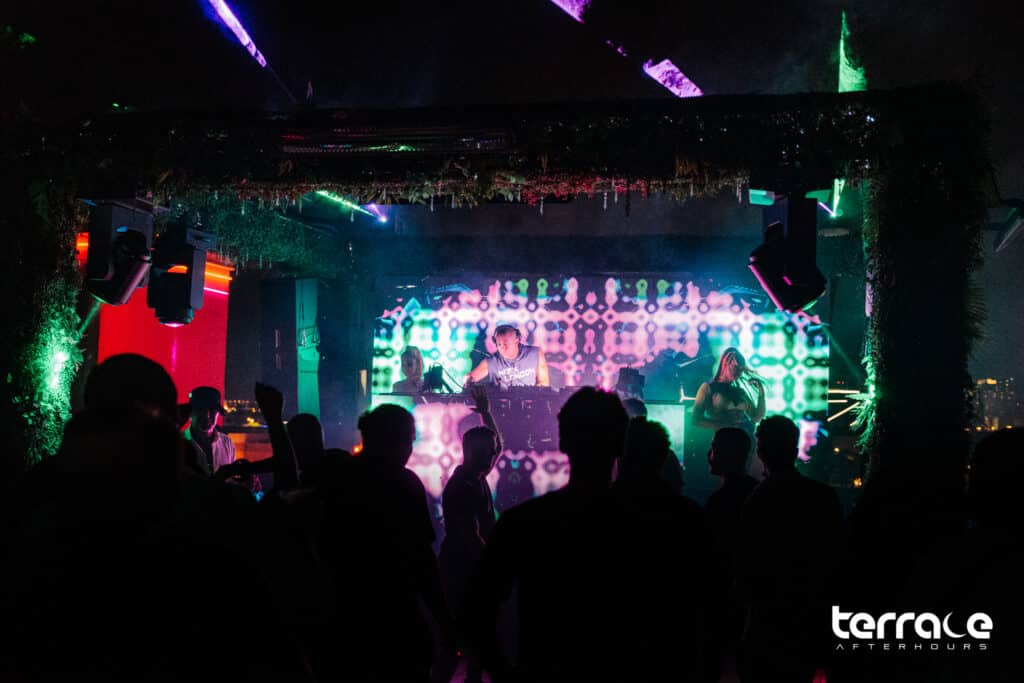 DJ illuminated by stage lights and LED backdrop at las Vegas afterhours club